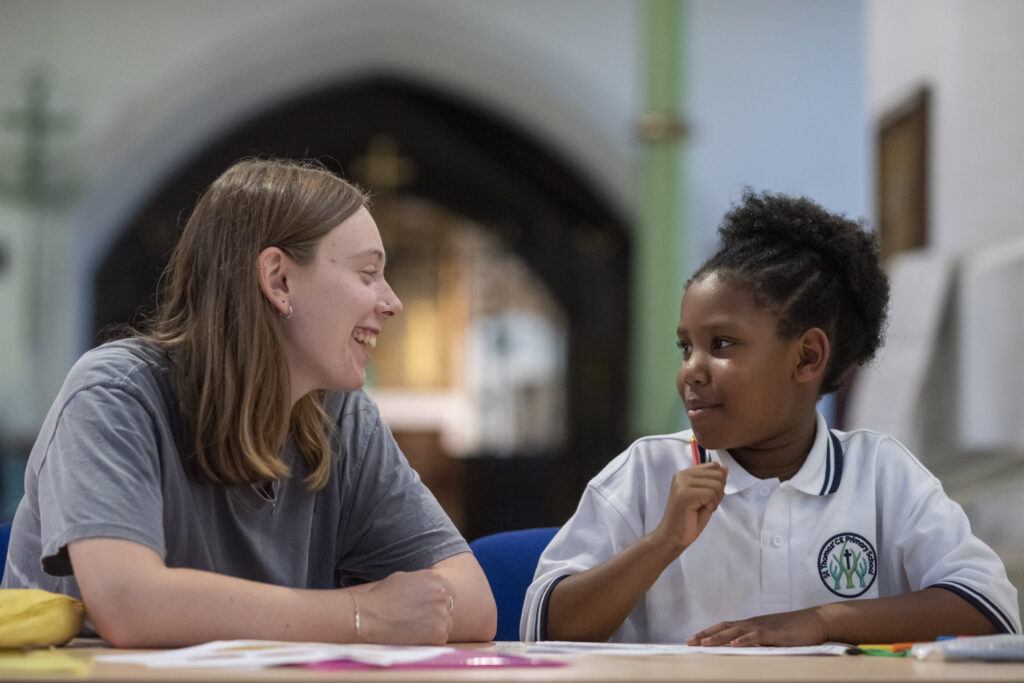 an adult and child sitting and talking in a learning environment